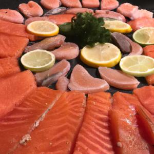 Lachs und Thunfisch mit Kräutern und Zitrone arrangiert. Diese fettigen Fische enthalten bestimmte Fette, die entzündungshemmend wirken und Migräneattacken reduzieren.